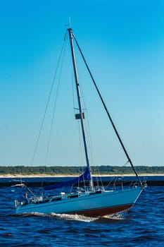 Small sailboat jumping on the waves at summer