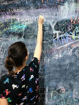 Back to school. A child paints scribbles by chalk on a board