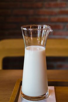 A glass of fresh milk on wooden table