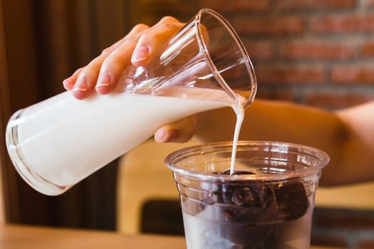 Fresh milk pouring into glass with frozen chocolate