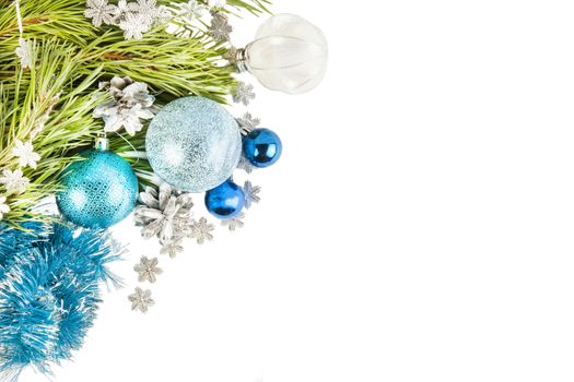 Fir tree branch and cones with blue balls and tinsel isolated on white