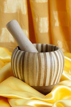 a bamboo mortar over a yellow fabric 