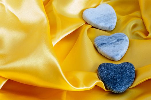 a three stone hearts over yellow fabric