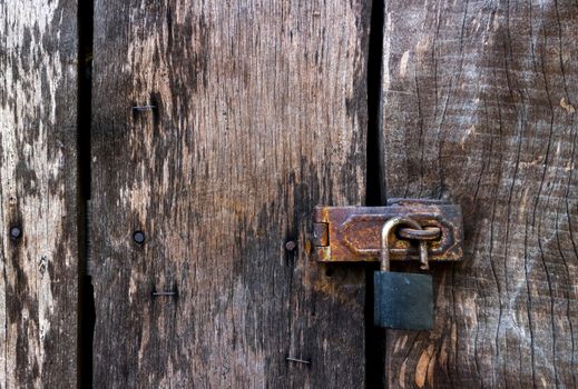 Old master key lock on old wooden background
