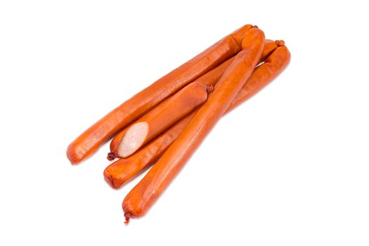 Several whole and one half of the long thin smoked hunting frankfurters in the natural casing on a light background
