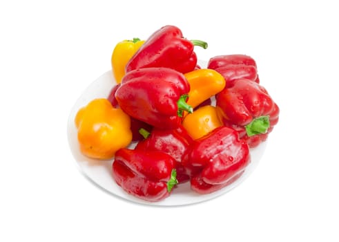Washed red and yellow bell peppers with water drops on the white dish on a white background
