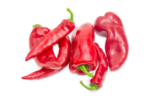 Several red bell peppers and red chili on a white background
