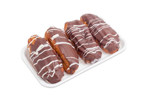 Several eclairs with chocolate icing on a foam food container on a white background
