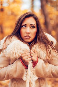 Portrait of a pensive young woman in forest in autumn. 