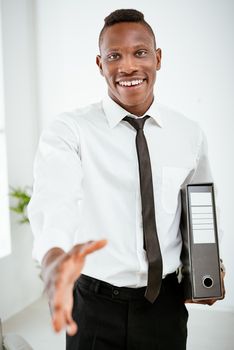 Successful African businessman with face out of focus shakes hands with unrecognizable business people.