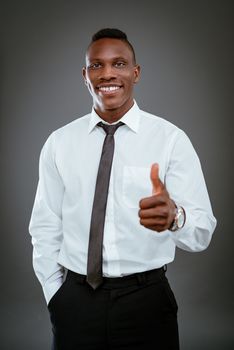 Smiling African businessman showing thumb up and looking at camera.