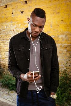 African guy wearing headphones and listening to music.