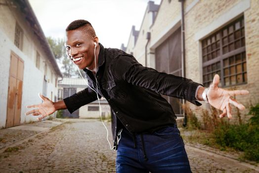 African guy wearing headphones and dancing.