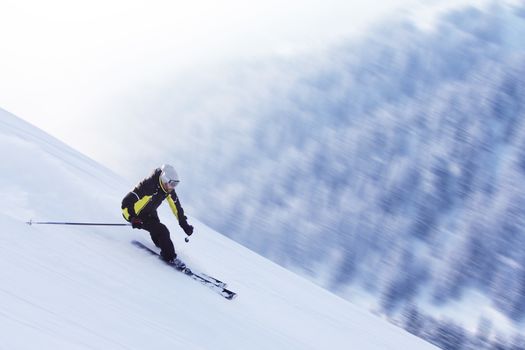 Skier skiing downhill in high mountains, Solden, Austria