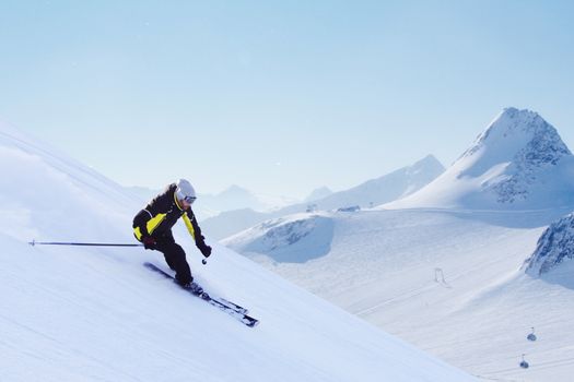 Skier skiing downhill in high mountains, Solden, Austria