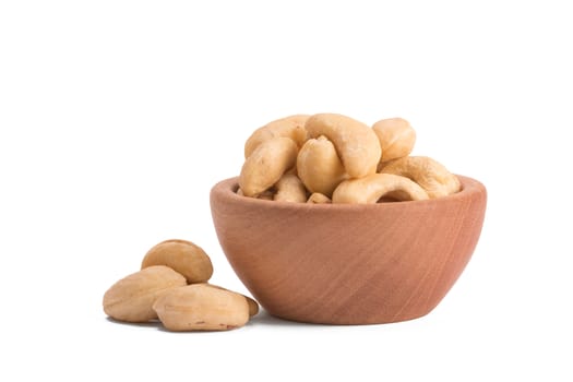 wooden bowl with cashews on a white background.