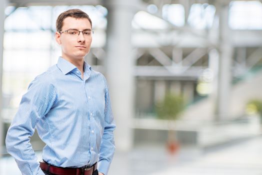 Successful male with glasses and blue shirt in office