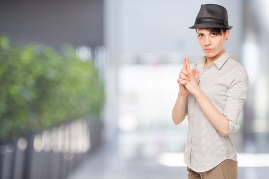 Detective woman thumbs gun in the office