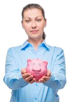 Businesswoman showing piggy bank on white background, piggy bank in focus