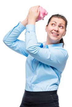 Portrait of a girl with a pink piggy bank in the studio on a white background