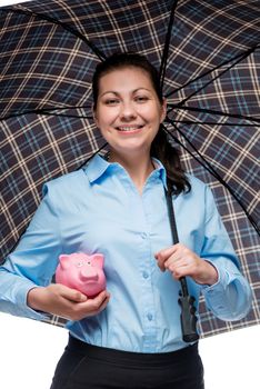 Savings under reliable protection! Happy businesswoman with a piggy bank under an umbrella