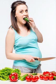 portrait of a young future mother with vegetables in the kitchen