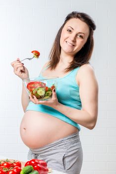 Happy beautiful woman with bowl of vegetable salad posing