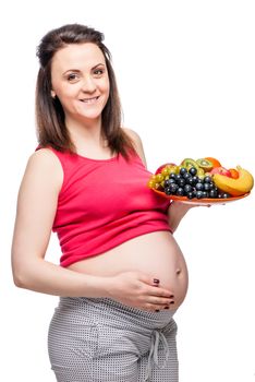 healthy happy pregnant woman with a plate of fruit isolated portrait