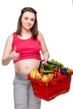 happy woman with shopping cart full of useful products on white background