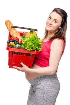 vertical portrait of a pregnant woman with a basket of useful products isolated