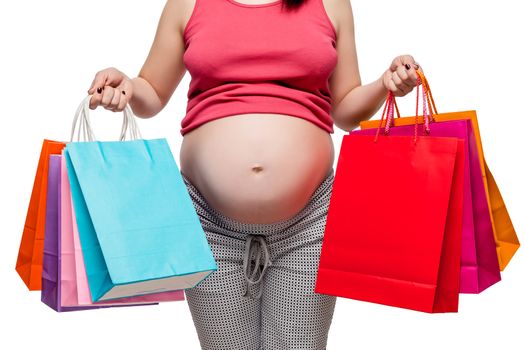 belly of a pregnant woman close-up on a white background, in the hands of shopping bags