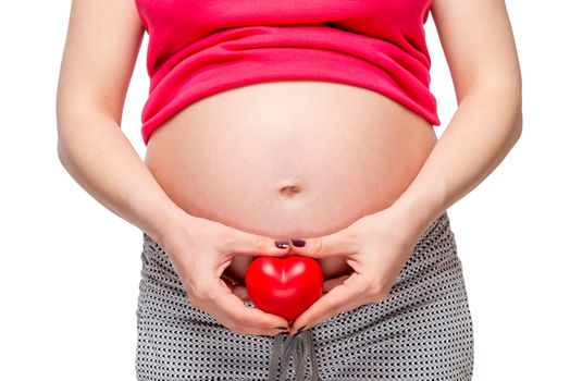 female hands holding a loving heart at the abdomen level, on a white background close-up