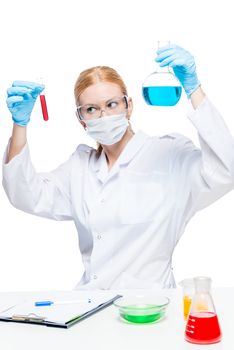Woman chemist lab assistant with test tubes doing substance analysis