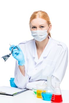 young laboratory girl at a table with test tubes posing