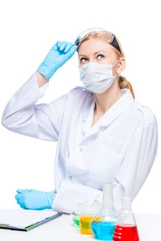 Chemist lab worker looks up, on the table are test tubes