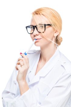 Woman doctor in glasses with pen posing in studio on white background