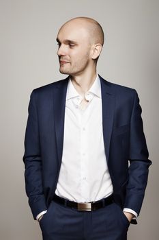 Studio shot of young man in suit. Gray background.