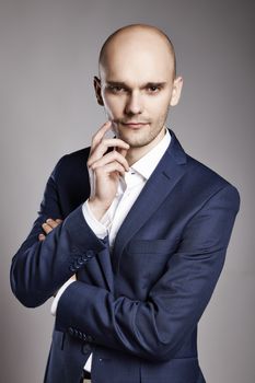 Portrait of young pensive man stroking his chin.