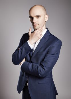 Portrait of young bald businessman looking at camera.