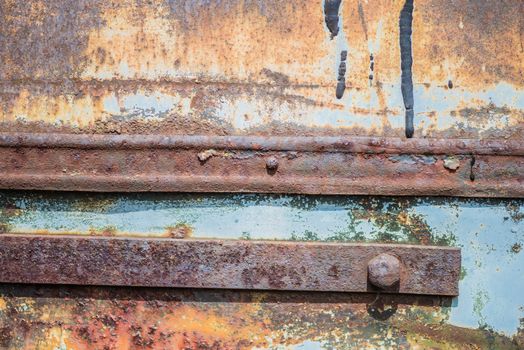 Old rusty metal grunge background with with two metal strips, blue paint flaking and cracking texture