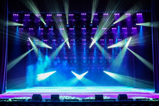 Illuminated empty show stage with blue light and stage fog