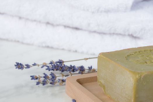Bar of natural handmade soap, lavender flowers and white terry towels