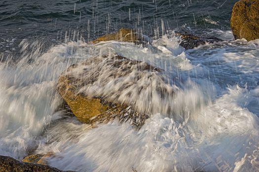 long exposure day seascape with slow shutter and water flowing over the stones