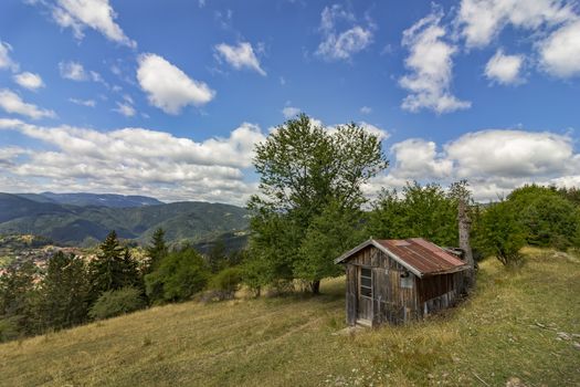 beauty daily landscape of alone old wooden house on a hill in a mountain