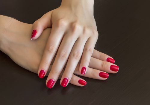Beautiful woman hands with red manicure Red nail polish.