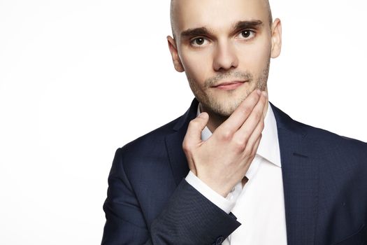 Portrait of a young man stroking his chin. Headshot on white background.
