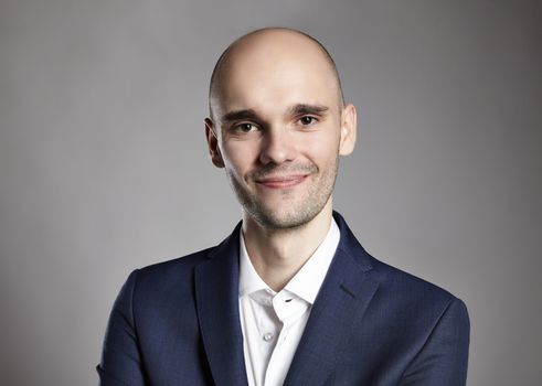 Portrait of young cheerful man in blue jacket. Headshot.