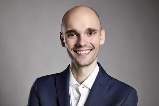 Portrait of young cheerful man in blue jacket. Headshot.