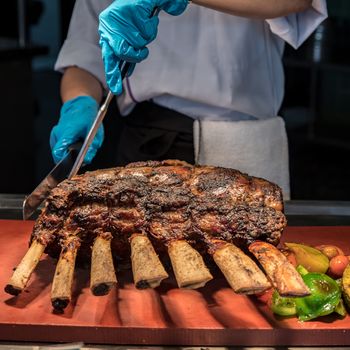 Chef Carving prime rib of  roast Wagyu beef 