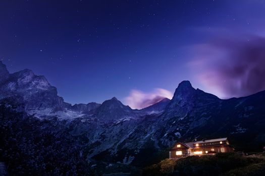 Dramatic night photo of Tatra mountains with touristic shelter